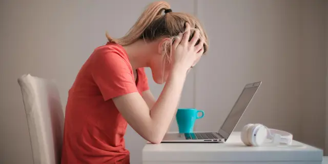 Una studente di fronte ad un computer con le mani nei capelli