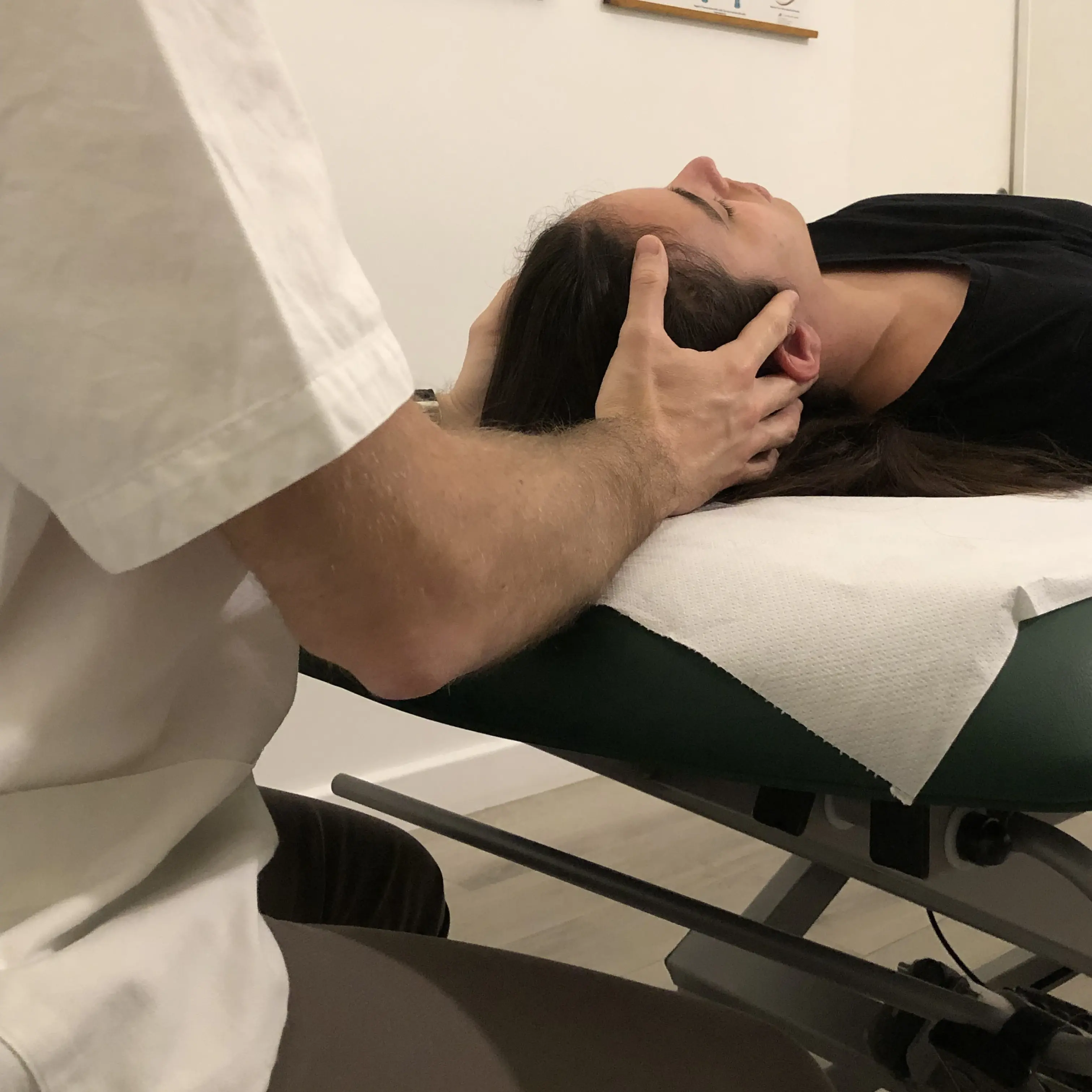 Marco De Canal tratta il cranio di una paziente, seduto alla testa del lettino