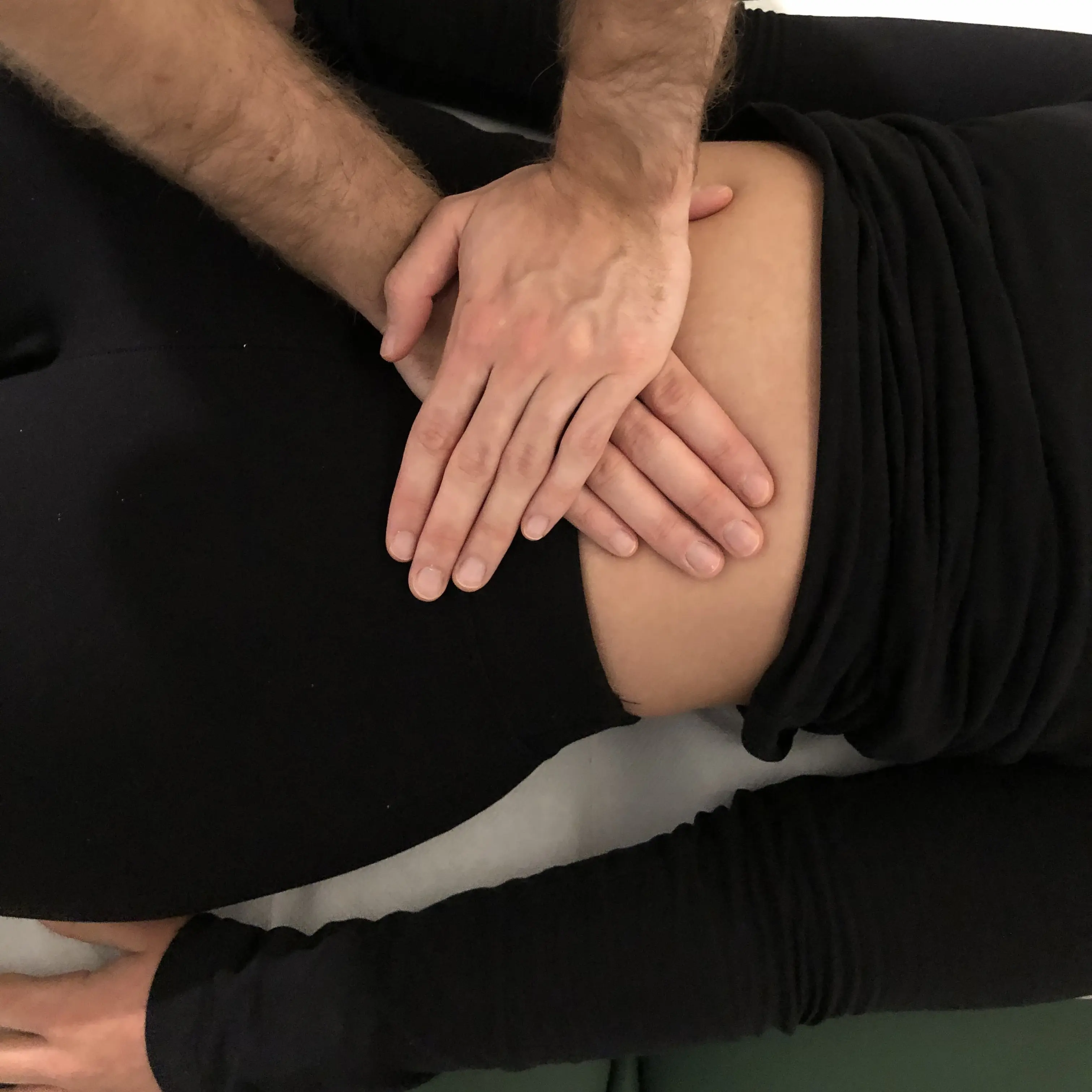 Mani di Marco De Canal sulla pancia di una paziente per eseguire un trattamento viscerale dell'intestino tenue